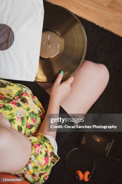 woman taking a vinyl out of its cover - album cover stock-fotos und bilder