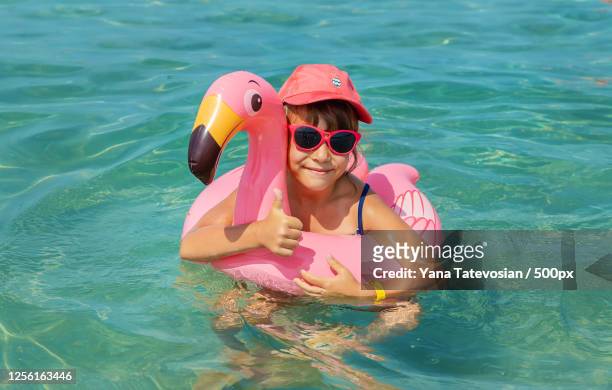 girl swimming in water with flamingo swim ring - tube girl bildbanksfoton och bilder