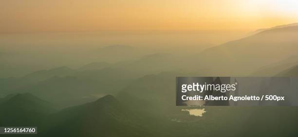foggy landscape of valley in mountain with lakes at sunset, fregona, veneto, italy - fregona stock pictures, royalty-free photos & images