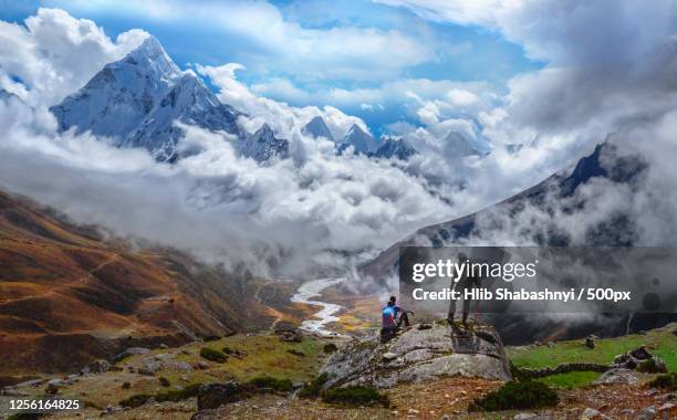majestic view of cloudy ama dablam and khumbu valley with hikers in awe, kathmandu, nepal - ama dablam stock pictures, royalty-free photos & images