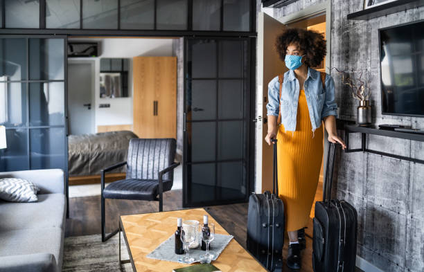 beautiful afro woman with protective face mask arriving in hotel room