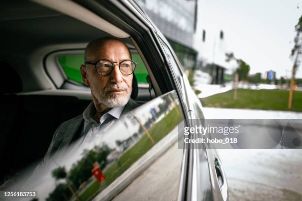 geschäftsmann auf dem rücksitz des autos - businessman taxi stock-fotos und bilder