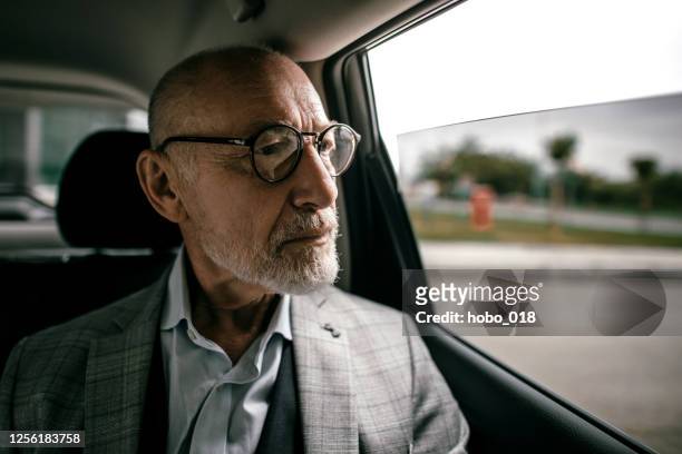 senior geschäftsmann im taxi - auto tablet stock-fotos und bilder