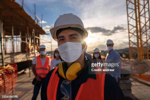 retrato de un trabajador de la construcción feliz en un sitio de construcción - carrera fotografías e imágenes de stock