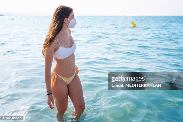 tourist bikini girl with face mask in pandemic on beach - swimsuit models girls stock pictures, royalty-free photos & images