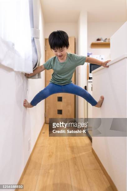 little boy climbing up the room in living room - child climbing stock pictures, royalty-free photos & images