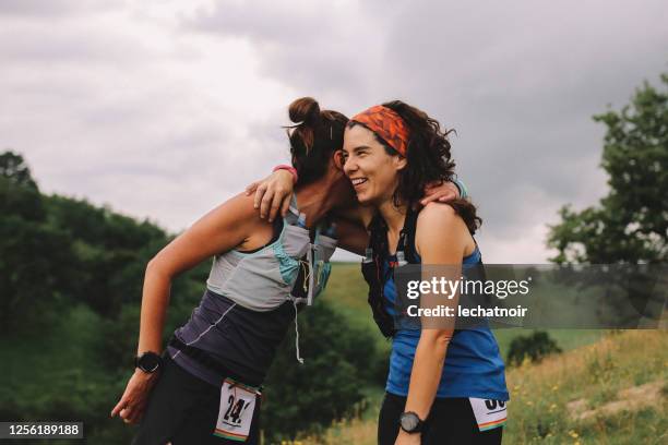 duas corredoras comemoram na natureza - meia maratona - fotografias e filmes do acervo