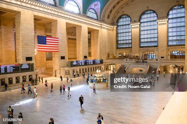 People wear protective face masks in Grand Central Terminal as the city moves into Phase 3 of re-opening following restrictions imposed to curb the...