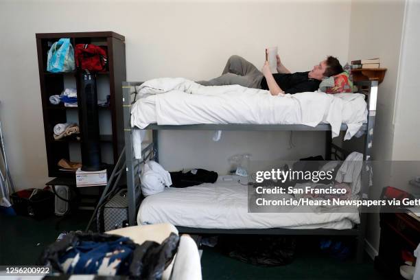 HealthRIGHT 360 client Brian Parner reads a book on his bunk at the residential drug treatment program in San Francisco, Calif., on Wednesday, May...