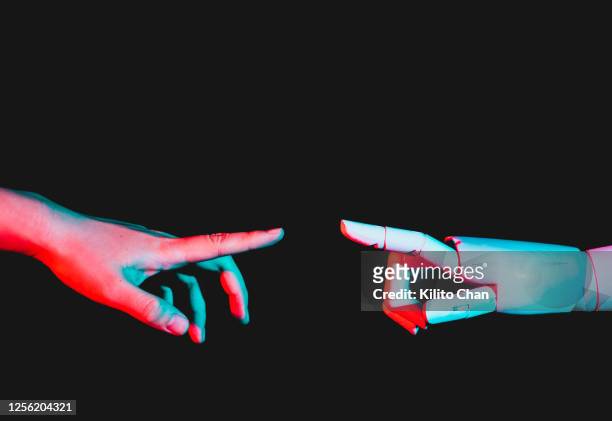 human hand reaching for robotic hand - fake stock-fotos und bilder