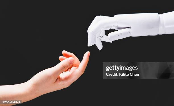 human hand reaching for robotic hand - bionic human stock pictures, royalty-free photos & images