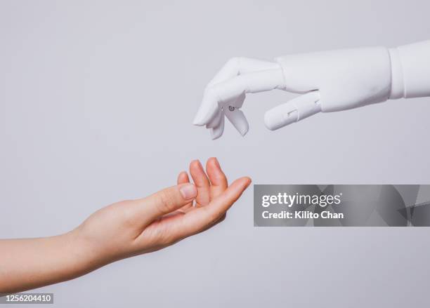 human hand reaching for robotic hand - humano-robot fotografías e imágenes de stock