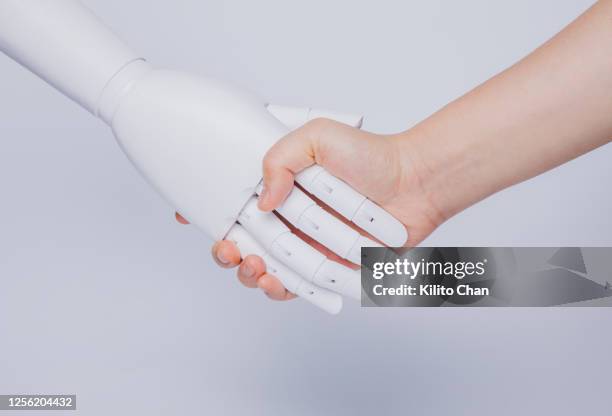 human hand shaking robotic hand - artificial arm stock pictures, royalty-free photos & images