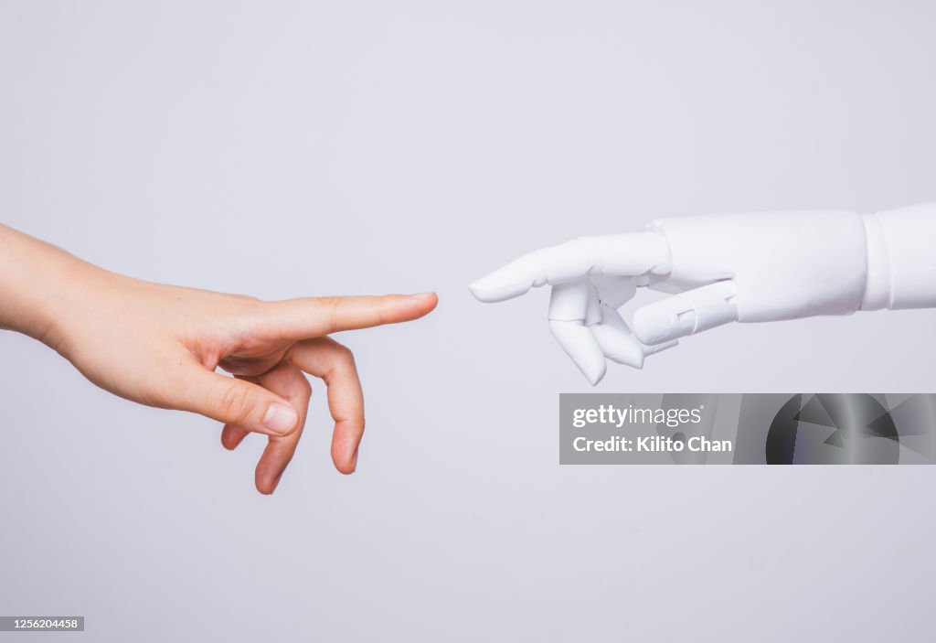Human hand reaching for robotic hand