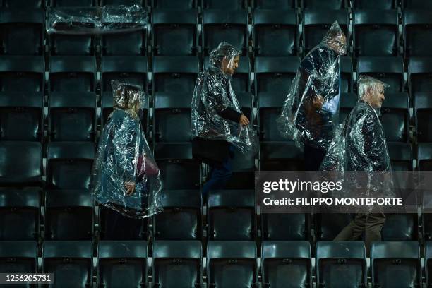 Spectators leave a tribune of the Central Court as the rain interrupts the semifinals match of the Women's WTA Rome Open tennis tournament between...