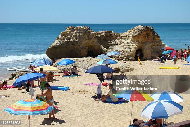 people relaxing on beach, albufeira - albufeira beach stock pictures, royalty-free photos & images