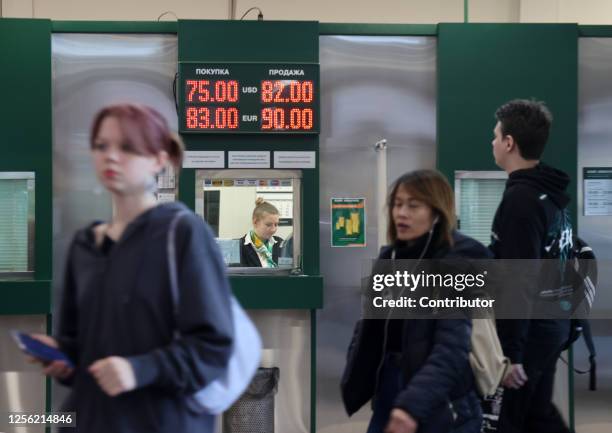 Cashier seen in the exchange banking office with panel of rates of US dollar and other currencies to ruble, in May 19 in Moscow, Russia. According to...