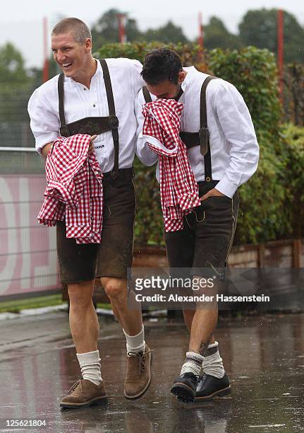 Bastian Schweinsteiger of FC Bayern Muenchen arrives with his team mate Diego Contento for the Paulaner photocall at Bayern Muenchen's trainings...