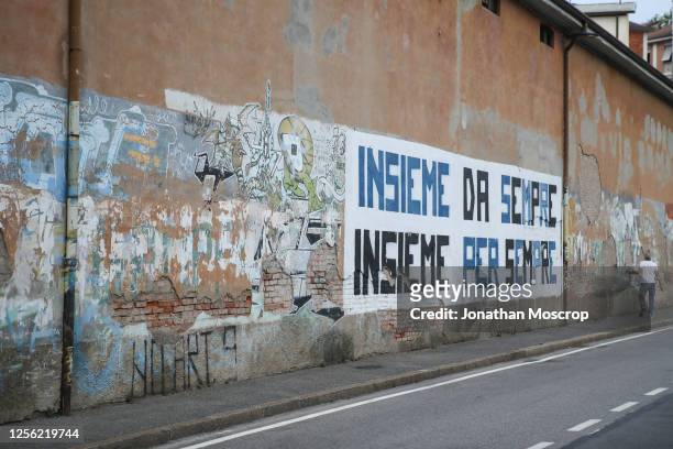 Man walks past a slogan on a building facade outside the ground before the Serie A match between Atalanta BC and Brescia Calcio at Gewiss Stadium on...