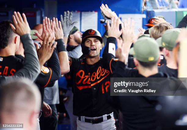 Adam Frazier of the Baltimore Orioles celebrates in the dugout after hitting a two-run home run in the ninth inning against the Toronto Blue Jays at...