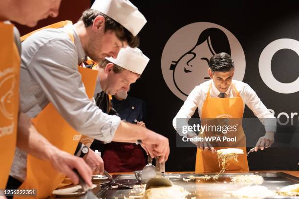 Prime Minister Rishi Sunak is shown how to make traditional Japanese Okonomiyaki pancakes at a restaurant with travelling British journalists on May...