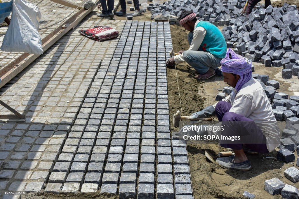 Laborers work at the construction site of the smart city...