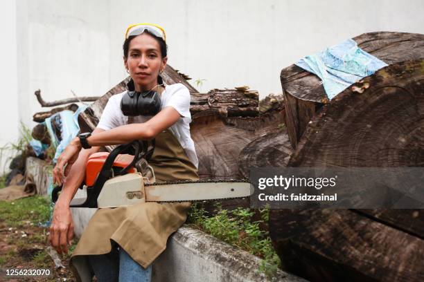 porträtt av en kvinna carpenter hålla en motorsåg - motorsåg bildbanksfoton och bilder