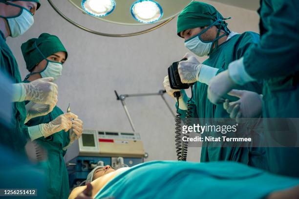 doctor preparing to using a defibrillator a patient in emergency room. - dead women stock-fotos und bilder