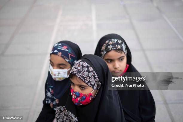 Young veiled Iranian girls sit at the Imam Khomeini grand mosque in downtown Tehran, during a ceremony marking national daughters day, May 19, 2023.