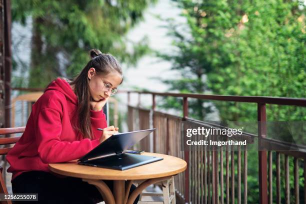 teenager-mädchen macht hausaufgaben auf dem balkon - digitized pen stock-fotos und bilder