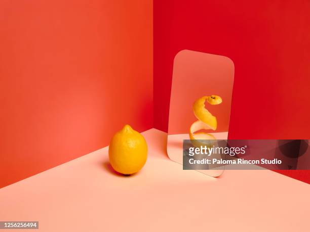 a lemon in a mirror reflecting an empty version of himself. - distorted image stockfoto's en -beelden