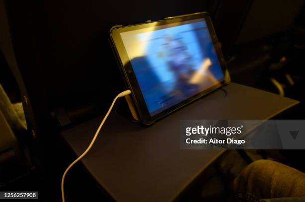 tablet on the airplane tray. somebody is looking at movie while flying. - airplane tray table stock pictures, royalty-free photos & images