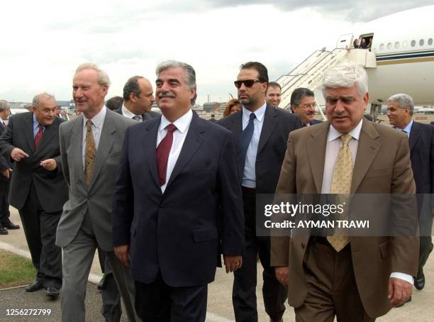 Lebanese Prime Minister Rafiq Hariri is flanked by British representative of the foreign ministry, Arthur Collins , and Lebanese ambassador in...