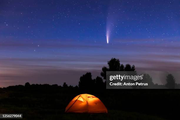 comet neowise c/2020 f3 over the orange tent on the river bank - cometa imagens e fotografias de stock