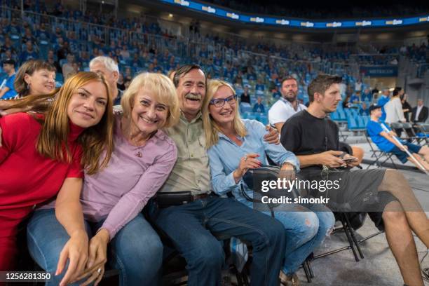 smiling family sitting in stadium - basketball fans stock pictures, royalty-free photos & images