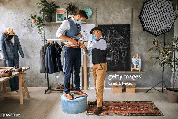 sastre senior tomando medidas de cintura para un traje hecho a mano - sastre fotografías e imágenes de stock