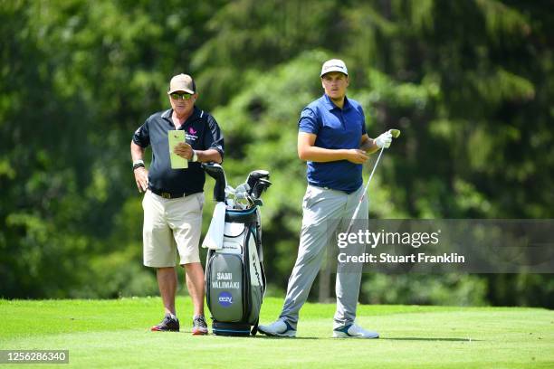 Sami Valimaki of Finland talks with his caddie Kyle Roadley on the 14th hole during day one of the Euram Bank Open at Golf Club Adamstal on July 15,...