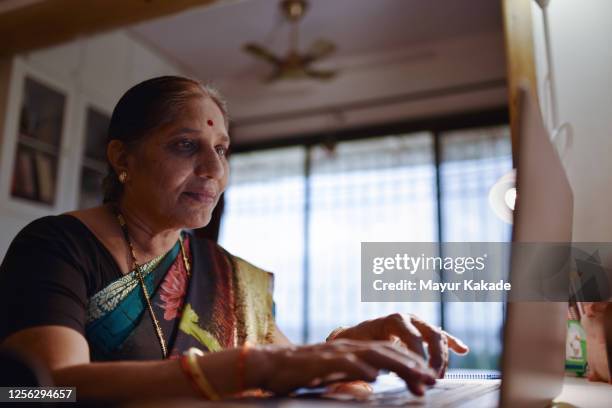 senior woman using laptop - indian old woman stock-fotos und bilder