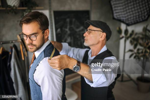 professional tailor taking back measurements for a suit - bespoke stock pictures, royalty-free photos & images