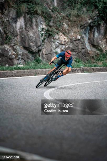 ciclista in bicicletta sulla curva della strada asfaltata - evento ciclistico foto e immagini stock