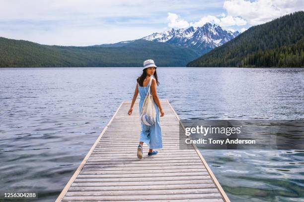 young woman walking on dock at mountain lake - bucket hat stock pictures, royalty-free photos & images