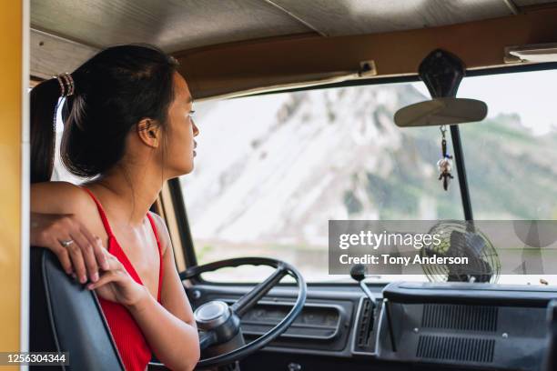 young woman looking out windshield of van - car top view foto e immagini stock