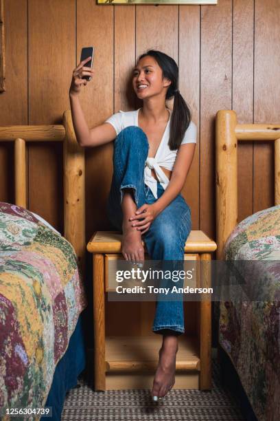 young woman using mobile phone indoors - businesswoman barefoot stock-fotos und bilder