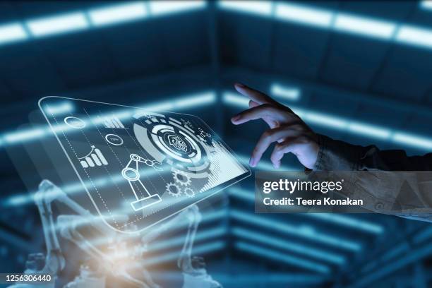 businessman pointing at hologram with icon on virtual screen, smart factory technology interface - robot hand human hand stock pictures, royalty-free photos & images