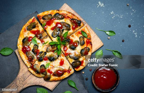 meeresfrüchte-pizza mit muscheln und käse mit basilikum verziert - clams cooked stock-fotos und bilder