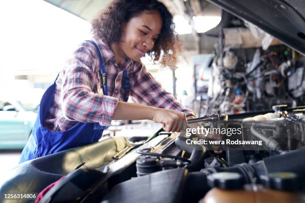 mechanic woman fixing car engines - adjusting ストックフォトと画像