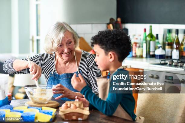 grandmother and grandson baking cupcakes - petit fils photos et images de collection