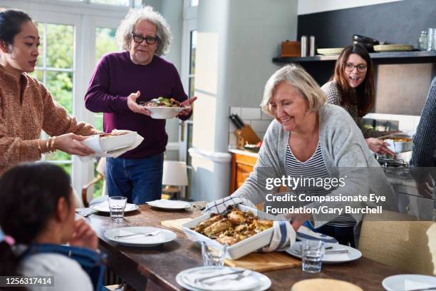 extended family having meal together - making dinner stock pictures, royalty-free photos & images