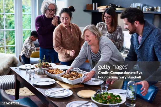 extended family having meal together - asian granny pics stock-fotos und bilder
