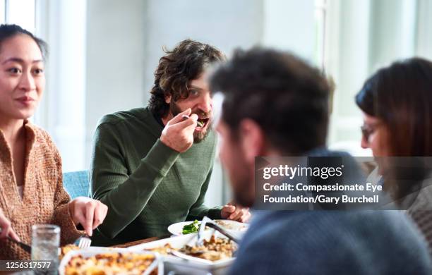 extended family having meal together - grupo pequeno de pessoas imagens e fotografias de stock